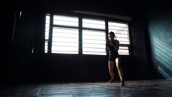 剪影美丽的年轻拳击女子训练拳击在健身室