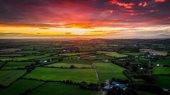 爱尔兰空中的乡村景观与田野和农田在戏剧性的日落天空下