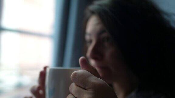 女人喝茶在早上醒来