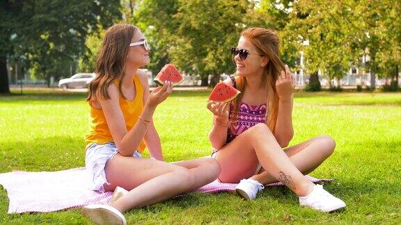 十几岁的女孩在公园野餐时吃西瓜