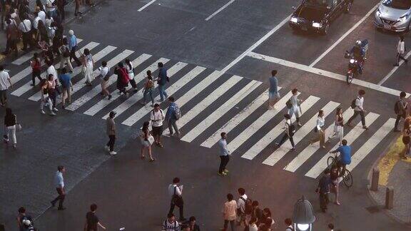 高角度延时拍摄的人走在人行横道晚上人行横道上挤满了人的大城市