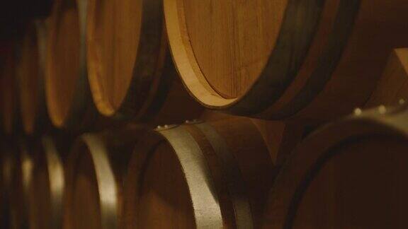 在大仓库里存放葡萄酒、白兰地或威士忌的陈年木桶多利万向节的运动一长排葡萄酒桶在一个葡萄酒厂与酒精酿酒及发酵工艺