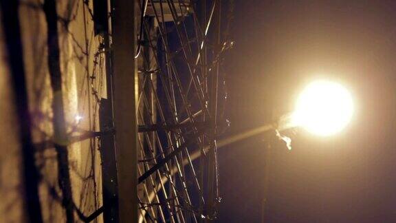 有铁丝网的大篱笆在夜里被灯笼照亮