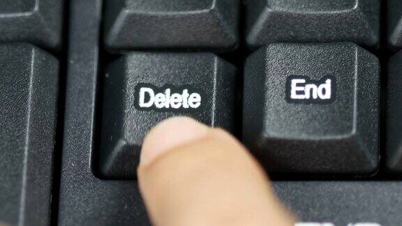 人的手指在电脑键盘上按下删除键的特写