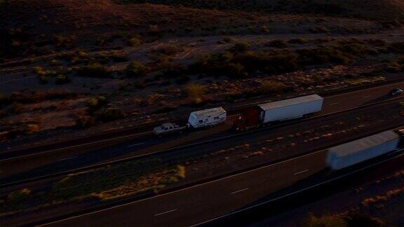 图片:夏日日落时分汽车和半卡车在繁忙的高速公路上行驶