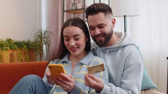 家庭已婚夫妇使用信用卡银行卡智能手机转账购买网上购物