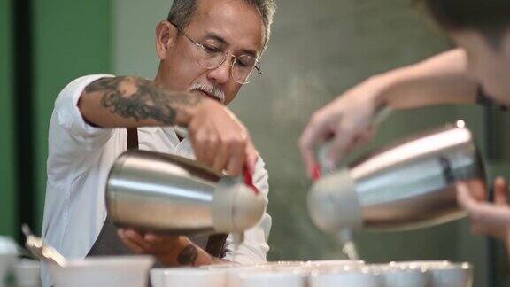 专业亚洲华人高级男咖啡师品级员将热水倒入陶瓷咖啡杯中准备拔杯咖啡品质测试