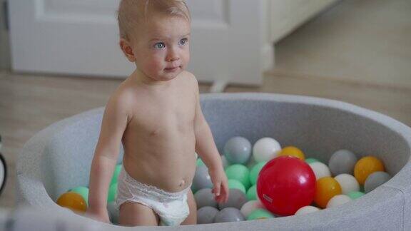 有孩子在家里玩球池快乐的孩子在软球坑水池与五颜六色的球幼儿白人婴儿男孩有乐趣玩在家里