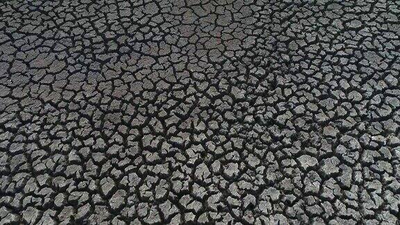 由于气候变化和全球变暖导致的干旱一个干坝的泥面有图案的裂缝