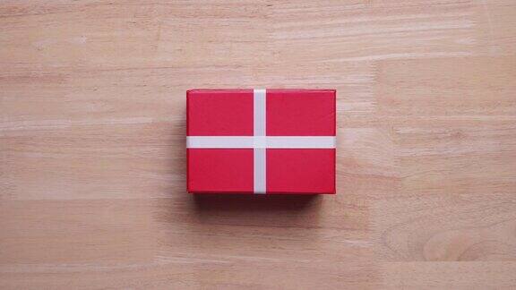 4k定格:木制背景上的红色礼盒