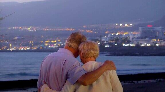 老年情侣在黄昏的海边相爱4k慢镜头60fps