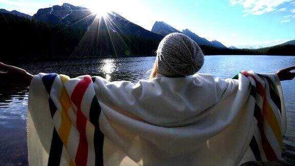 快乐的年轻女子在加拿大的山湖边放松