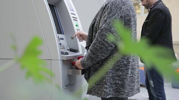 高级女性使用ATM机手持射击