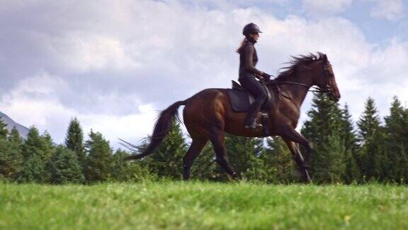 SLOMOTS女人骑着疾驰的马穿过山区草地