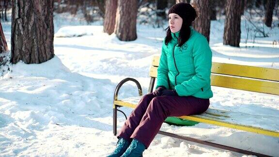 冬天里坐在长椅上的悲伤女人