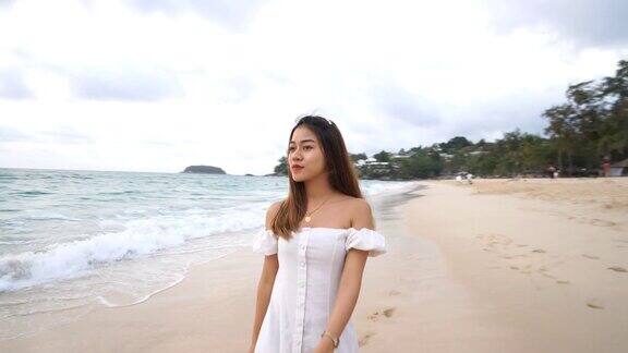 一个可爱的亚洲女孩在阴天的海滩上