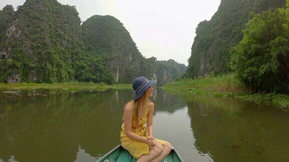 在越南北部的旅游胜地宁平一名年轻女子在船上在壮观的石灰岩中漂流去越南旅游