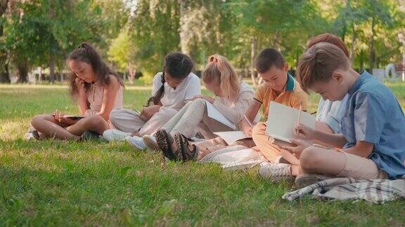 小学生在公园里用笔记本画画