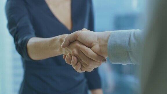 心不在焉的女商人和一个商人握手手的焦点通过握手敲定交易和签订合同