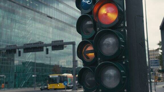 德国首都柏林市中心十字路口的一个典型的红绿灯绿色箭头是亮的切换到黄色和红色背景中是不知名的自行车手和一辆公共汽车街道上的交通特写镜头