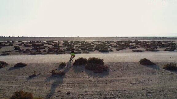从无人机鸟瞰跑步者在沙漠中慢跑