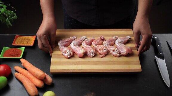 新鲜的生鸡翅放在切菜板上准备鸡棒棒糖