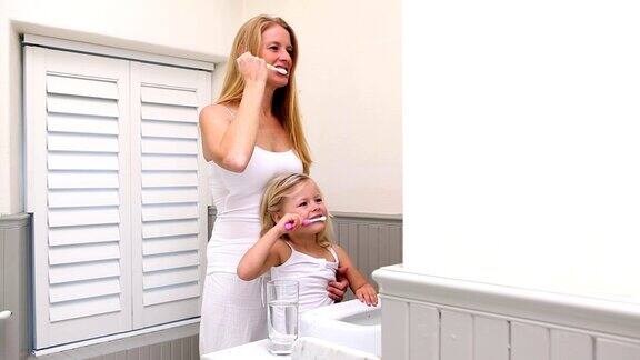 可爱的小女孩和妈妈一起刷牙