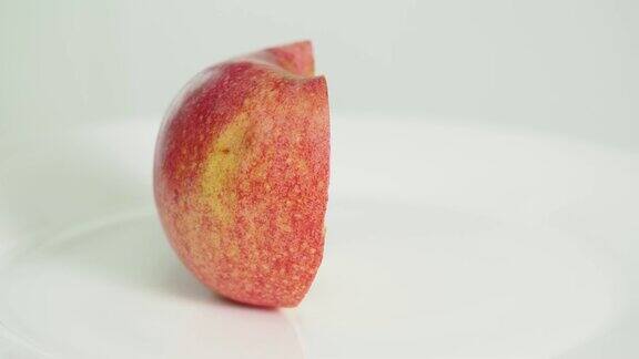 在白色盘子上切成两半的粉红色苹果水果第一部分