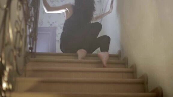 年轻女子在房子的楼梯上跳舞