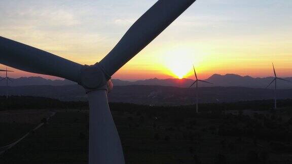 4k鸟瞰图的风力涡轮机在日落风车能源生产-绿色技术可再生能源解决方案