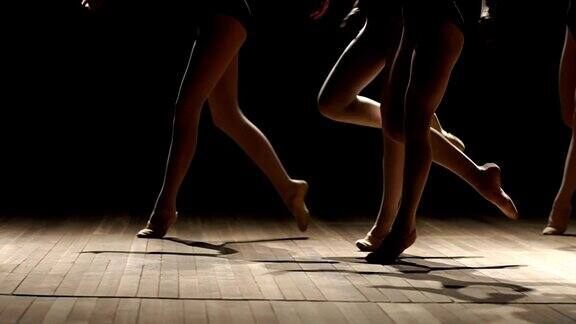 一群芭蕾舞者在黑暗中在舞台上跳舞