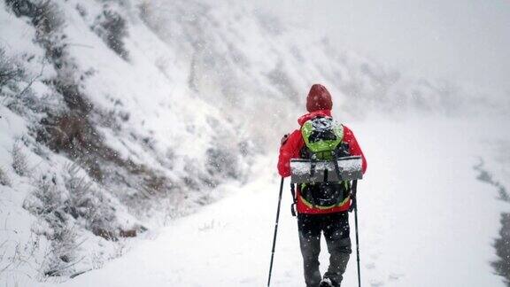 冬天在山里徒步旅行的背包客背影特写
