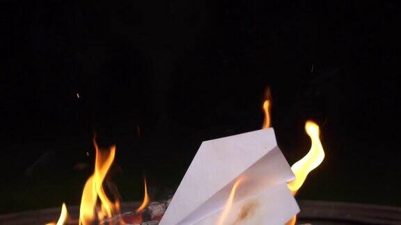 纸飞机掉进了火里火在黑暗中燃烧烧了备胎篝火纸飞机在飞危险的火灾安全技术人员