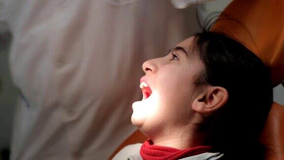 拔牙牙医为一个小女孩拔牙
