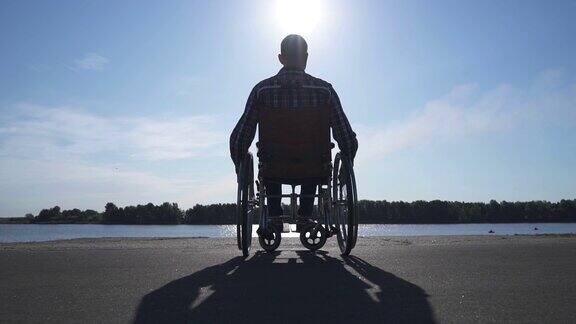 一个坐轮椅的男人在海滨散步