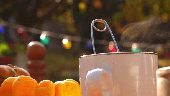 一个热气腾腾的一杯茶在温暖的秋天阳光户外的特写