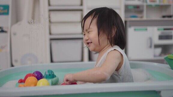 小孩子们在客厅的浴缸里玩玩具玩得很开心