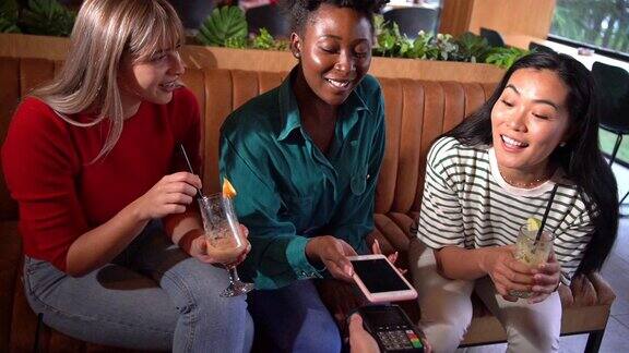 现代女性黑人在现代酒吧里通过手机app付费