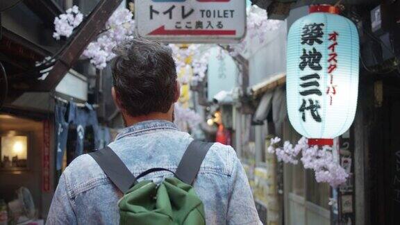 白种游客走在东京小巷的后视图
