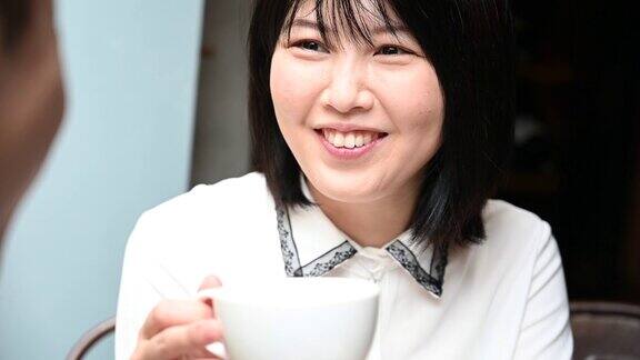一位中国妇女正在和朋友喝咖啡聊天