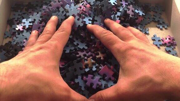 人类玩拼图游戏一个男人的手拼图捡起拼图碎片
