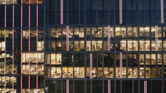右边是在电脑前工作到很晚的办公室和商务人员在夜间摩天楼的窗户上拍摄的全景照片