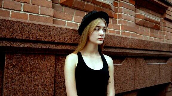 一个穿着黑色t恤和帽子的迷人的年轻女孩