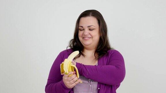 胖女孩一边吃香蕉一边竖起大拇指