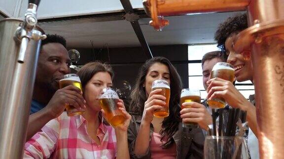 不同的朋友享受快乐时光喝啤酒祝酒和微笑