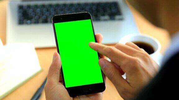 人类的手使用绿色屏幕的手机