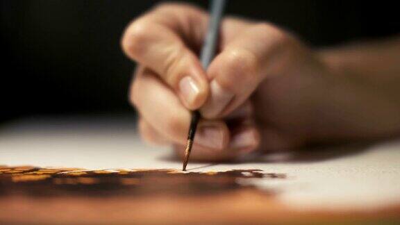 女手创意艺术家用画笔在相册纸近距离画