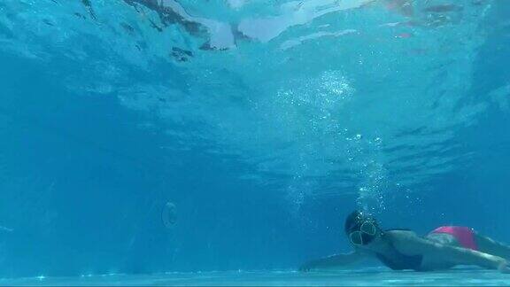 戴着面具的女孩在游泳池里看着镜头泡泡阳光