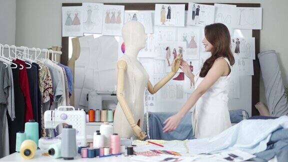 女时装设计师在她的工作室与人体模型跳舞