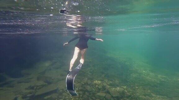 亚洲女子在清澈的水中自由潜水